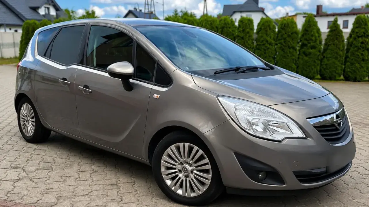 Szary Opel Meriva 1.7 CDTI na podjeździe. Zastanawiasz się nad wadami i zaletami tego modelu?