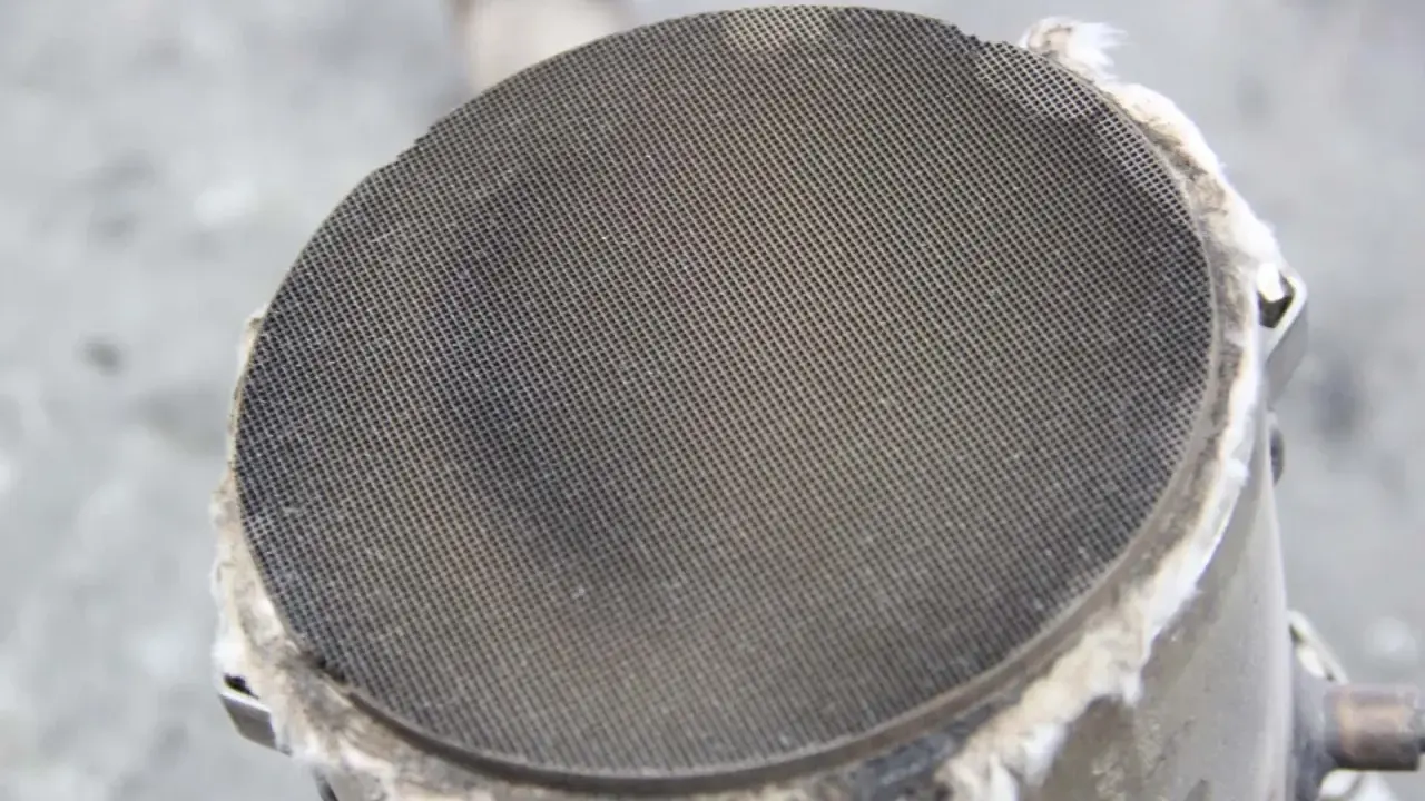 Filtr cząstek stałych (DPF) w samochodzie. Widoczny metalowy wkład z drobnymi otworami, który zatrzymuje sadzę.
