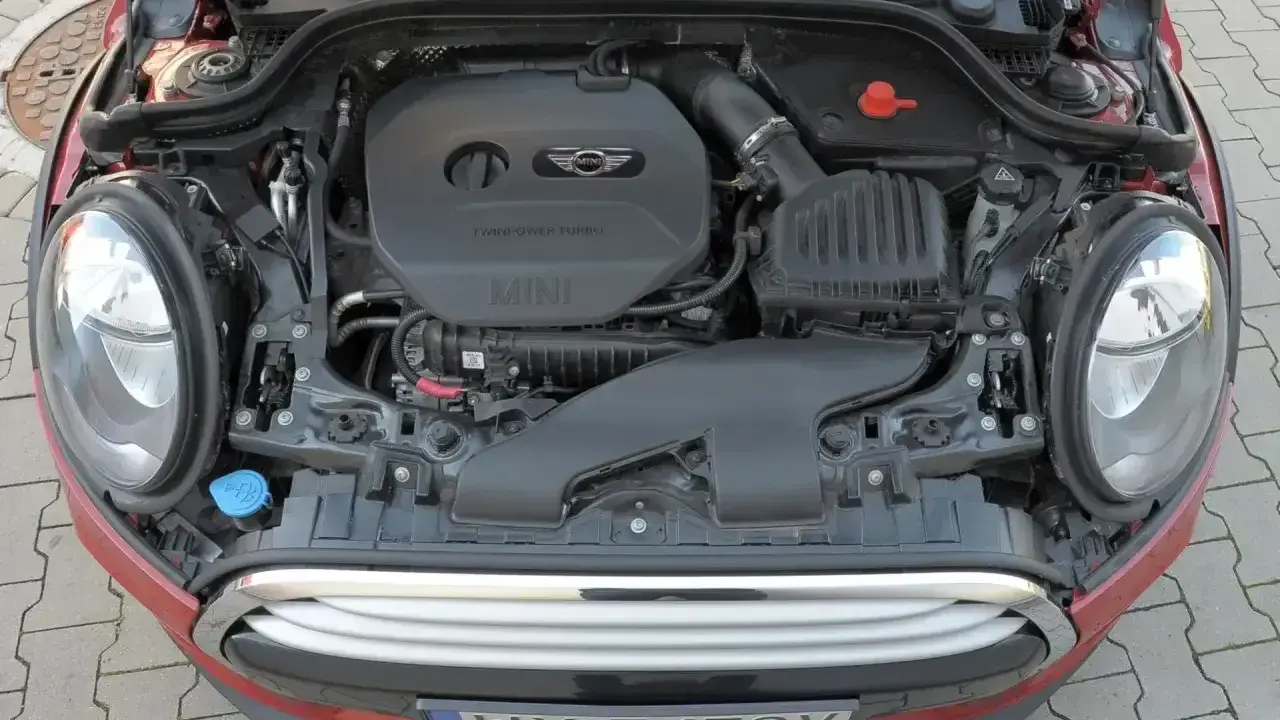 Otwarta maska czerwonego Mini Cooper ukazuje silnik TwinPower Turbo.
