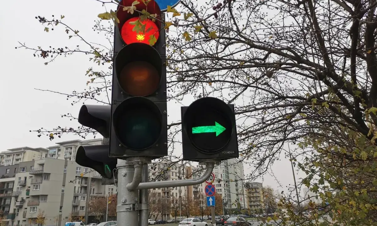 Sygnalizacja świetlna: czerwone światło główne i zielona strzałka warunkowa w prawo.