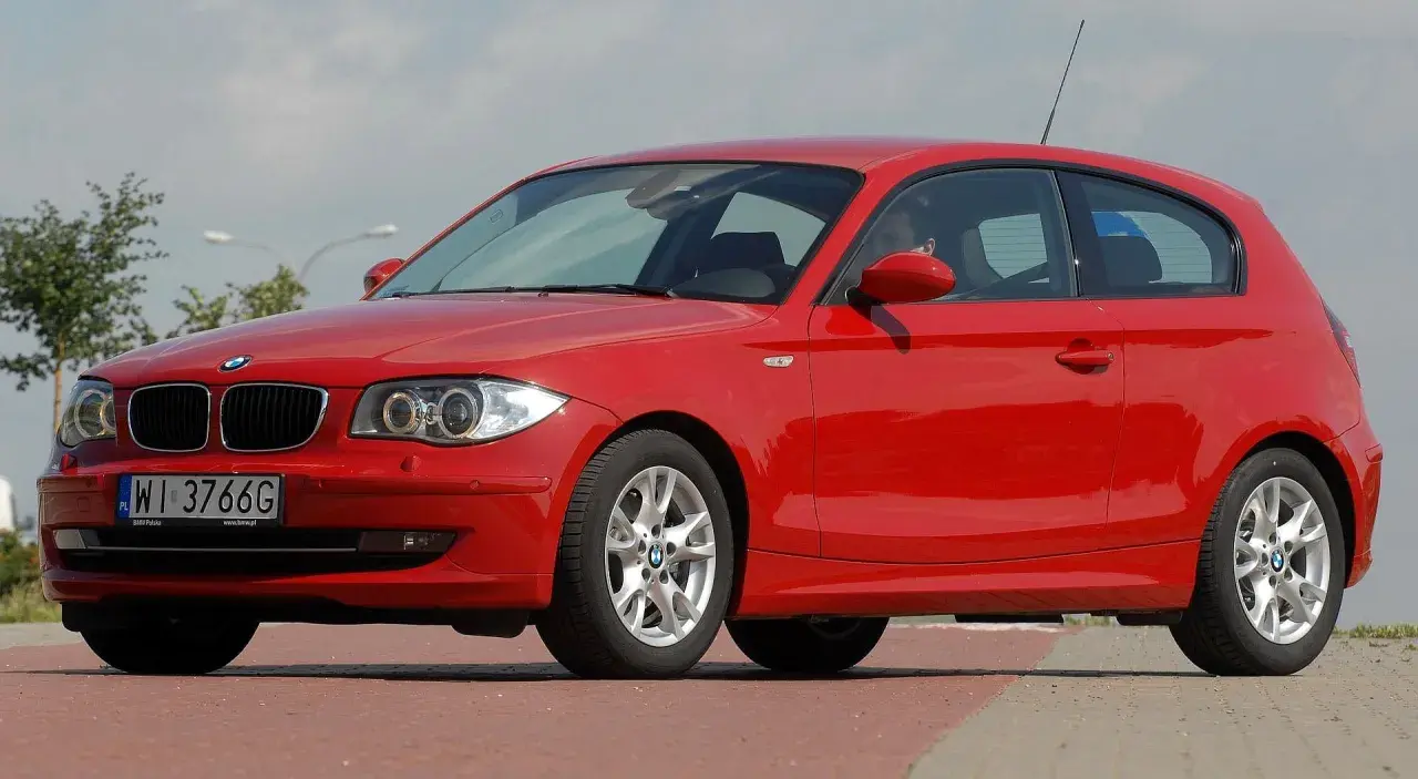 Czerwone BMW serii 1, jeden z klasycznych bmw modele stare, zaparkowane na ulicy.