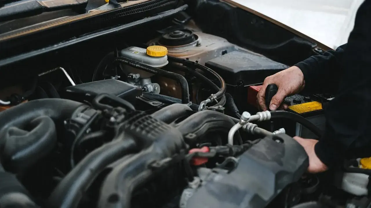 Mechanik pracuje przy silniku, sprawdzając, czy sucha miska olejowa jest szczelna.
