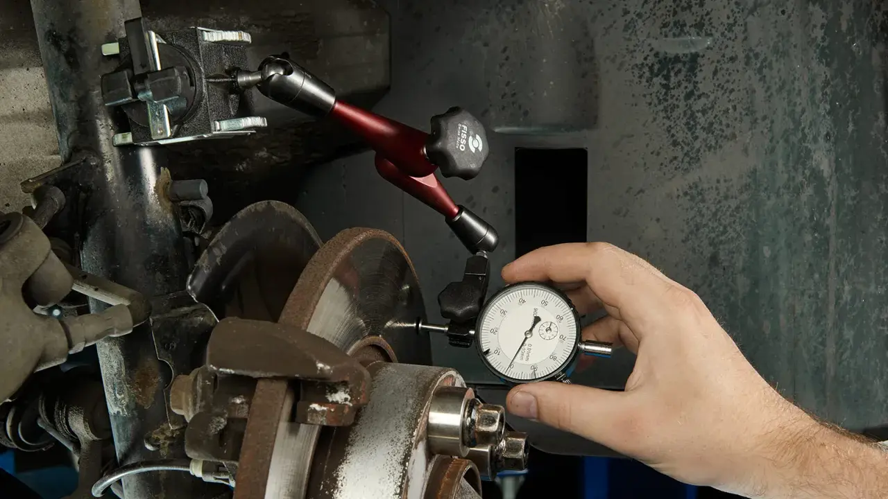 Mechanik mierzy bicie przy hamowaniu z dużej prędkości za pomocą czujnika zegarowego.