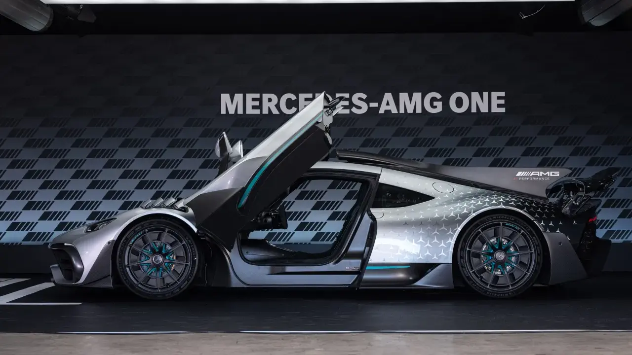 Srebrny Mercedes-AMG ONE z otwartymi drzwiami i maską, prezentujący futurystyczny design i sportowe osiągi.