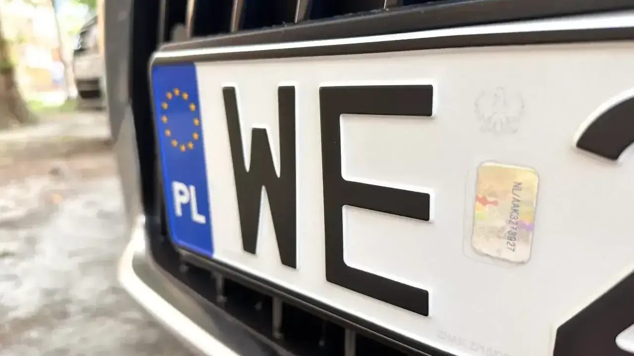 Zbliżenie na polską tablicę rejestracyjną z literami "WE". Zastanawiasz się, ile kosztują tablice rejestracyjne?