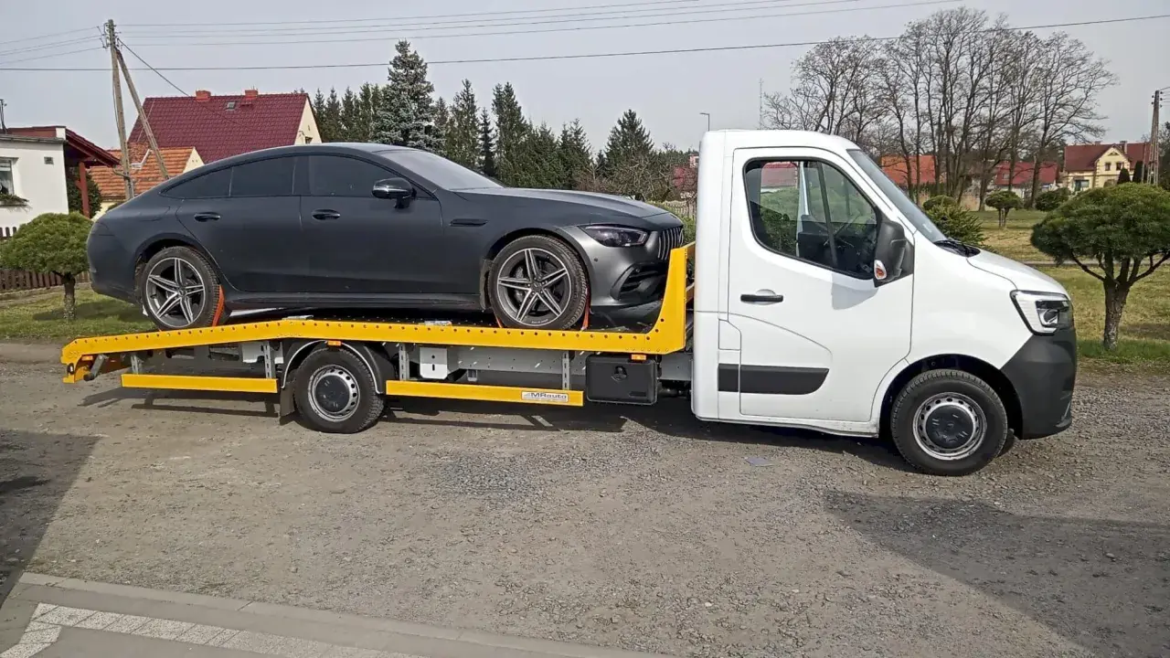 Auto na lawecie, ciemnoszary Mercedes. Zapewne zgodnie z przepisami dotyczącymi holowania auta.