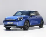 Niebieski Mini Cooper z białym dachem, jeden z tych małych aut, które pokochasz.