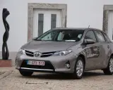 Szary Toyota Auris 1.6 benzyna, idealny do miasta, z niskim spalaniem. Obok rzeźba.
