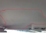 Opadająca podsufitka w samochodzie, zaznaczona czerwoną linią. Rozwiązaniem może być naprawa podsufitki pinezkami.