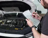 Mechanik sprawdza listę kontrolną przed przeglądem technicznym samochodu. Oplata za przeglad jest już ustalona.