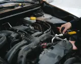 Mechanik pracuje przy silniku, sprawdzając, czy sucha miska olejowa jest szczelna.