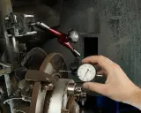 Mechanik mierzy bicie przy hamowaniu z dużej prędkości za pomocą czujnika zegarowego.