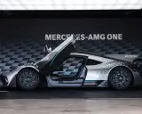 Srebrny Mercedes-AMG ONE z otwartymi drzwiami i maską, prezentujący futurystyczny design i sportowe osiągi.