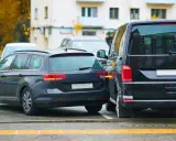 Ciemny kombi zaparkowany zbyt blisko drugiego samochodu, ledwo mieszcząc się na miejscu parkingowym.