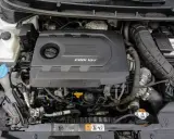Silnik CRDi 1.6V w samochodzie. Widoczny czarny plastikowy dekiel silnika z napisem CRDi 16V, elementy układu dolotowego i chłodzenia.