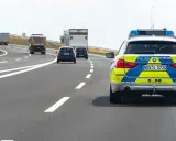 Niemiecka autostrada bez ograniczeń, gdzie policyjny radiowóz jedzie za innymi pojazdami.