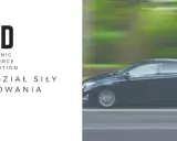 EBD - elektroniczny rozdział siły hamowania. Ciemny samochód w ruchu, zamazane tło.
