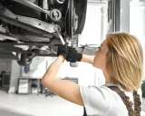 Mechanik sprawdza podwozie auta, szukając objawów uszkodzonego amortyzatora.
