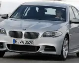 Srebrne BMW z kierowcą za kierownicą, gotowe do liftingu auta na zimowej drodze.