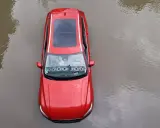 Czerwony samochód stoi w wodzie. Po powodzi czeka go osuszanie auta.
