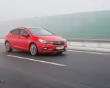 Czerwona Astra na autostradzie w mgle. Zastanawiasz się, ile pali Opel Astra? Ten model może być zaskakująco oszczędny.