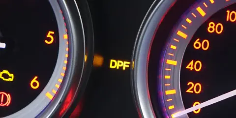 Żółta kontrolka DPF świeci się na desce rozdzielczej, sygnalizując potencjalne problemy z filtrem cząstek stałych.