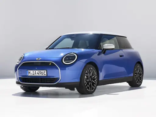 Niebieski Mini Cooper z białym dachem, jeden z tych małych aut, które pokochasz.