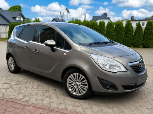 Szary Opel Meriva 1.7 CDTI na podjeździe. Zastanawiasz się nad wadami i zaletami tego modelu?