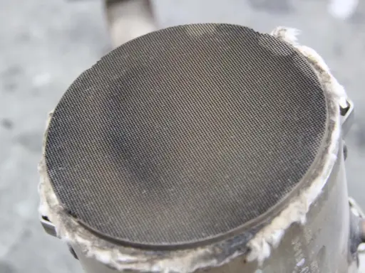 Filtr cząstek stałych (DPF) w samochodzie. Widoczny metalowy wkład z drobnymi otworami, który zatrzymuje sadzę.