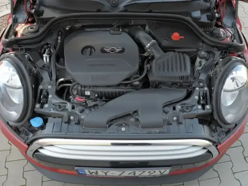 Otwarta maska czerwonego Mini Cooper ukazuje silnik TwinPower Turbo.
