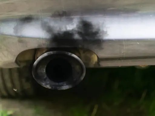 Zanieczyszczony układ wydechowy samochodu, czarny dym wydobywa się z rury. Czas na czyszczenie DPF.