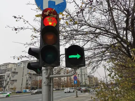 Sygnalizacja świetlna: czerwone światło główne i zielona strzałka warunkowa w prawo.