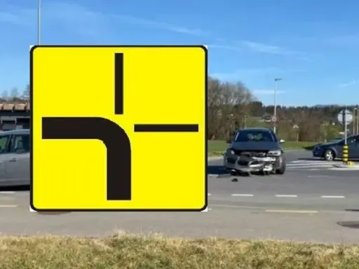 Znak drogi z pierwszeństwem przejazdu i uszkodzony samochód na skrzyżowaniu. Wypadek spowodowany łamanym pierwszeństwem.