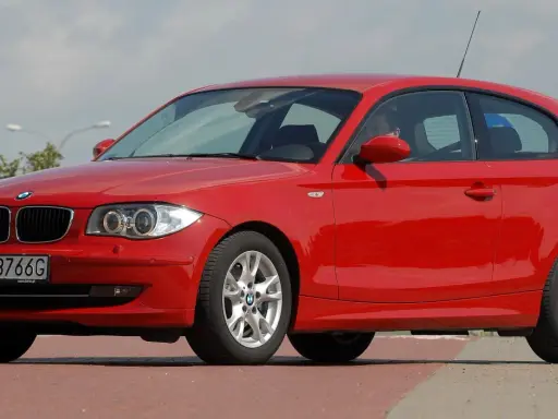 Czerwone BMW serii 1, jeden z klasycznych bmw modele stare, zaparkowane na ulicy.