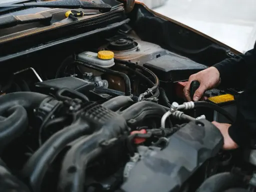 Mechanik pracuje przy silniku, sprawdzając, czy sucha miska olejowa jest szczelna.