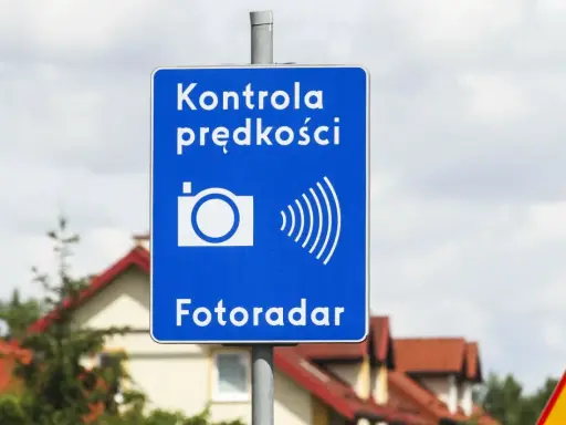 Niebieski znak informuje o kontroli prędkości. Fotoradar łapie kierowców przekraczających dozwoloną prędkość.