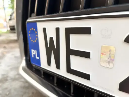 Zbliżenie na polską tablicę rejestracyjną z literami "WE". Zastanawiasz się, ile kosztują tablice rejestracyjne?
