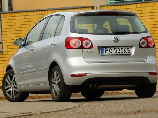Srebrny Golf 5 1.6 MPI z tablicą PO 535KS stoi przy żółtej ceglanej ścianie.
