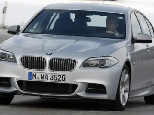 Srebrne BMW z kierowcą za kierownicą, gotowe do liftingu auta na zimowej drodze.