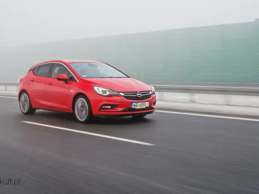 Czerwona Astra na autostradzie w mgle. Zastanawiasz się, ile pali Opel Astra? Ten model może być zaskakująco oszczędny.