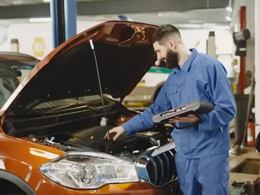 Mechanik z komputerem diagnostycznym sprawdza silnik. Zastanawiasz się, ile trwa wymiana oleju? To szybka usługa.