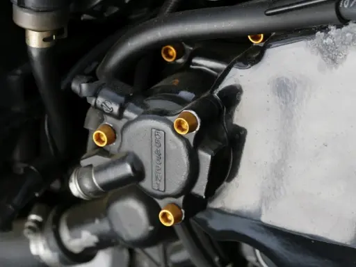 Elementy układu hydraulicznego motocykla, widoczna regulacja pedału sprzęgła hydraulicznego.