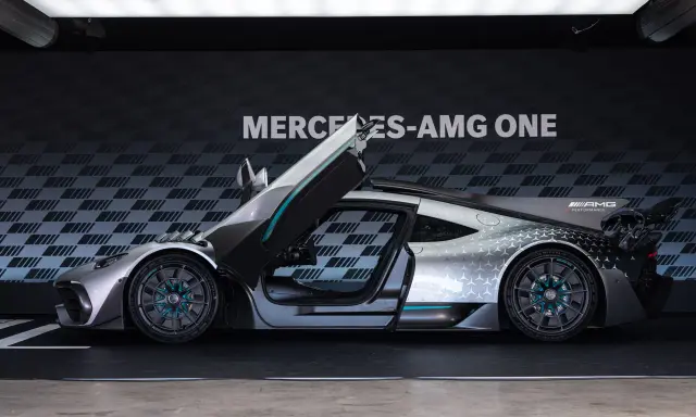 Srebrny Mercedes-AMG ONE z otwartymi drzwiami i maską, prezentujący futurystyczny design i sportowe osiągi.