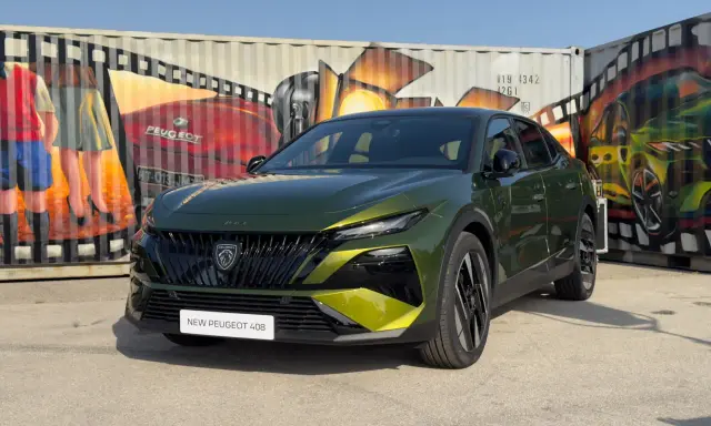 Nowy Peugeot 408 po lifcie, w kolorze zielonym, prezentuje się na tle kolorowych murali na kontenerach.