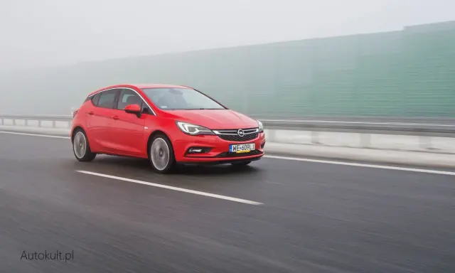 Czerwona Astra na autostradzie w mgle. Zastanawiasz się, ile pali Opel Astra? Ten model może być zaskakująco oszczędny.
