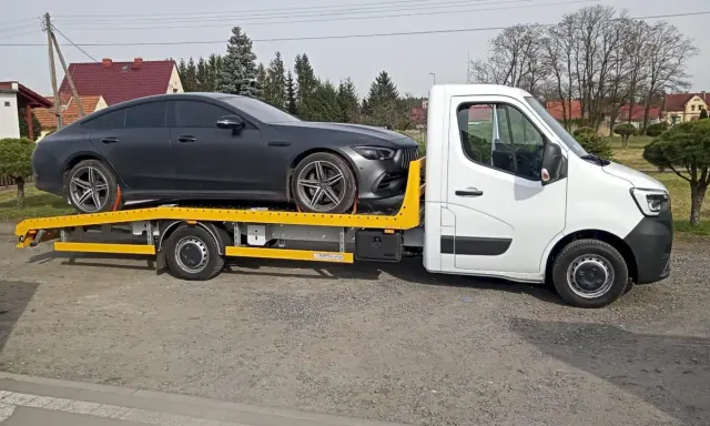 Auto na lawecie, ciemnoszary Mercedes. Zapewne zgodnie z przepisami dotyczącymi holowania auta.