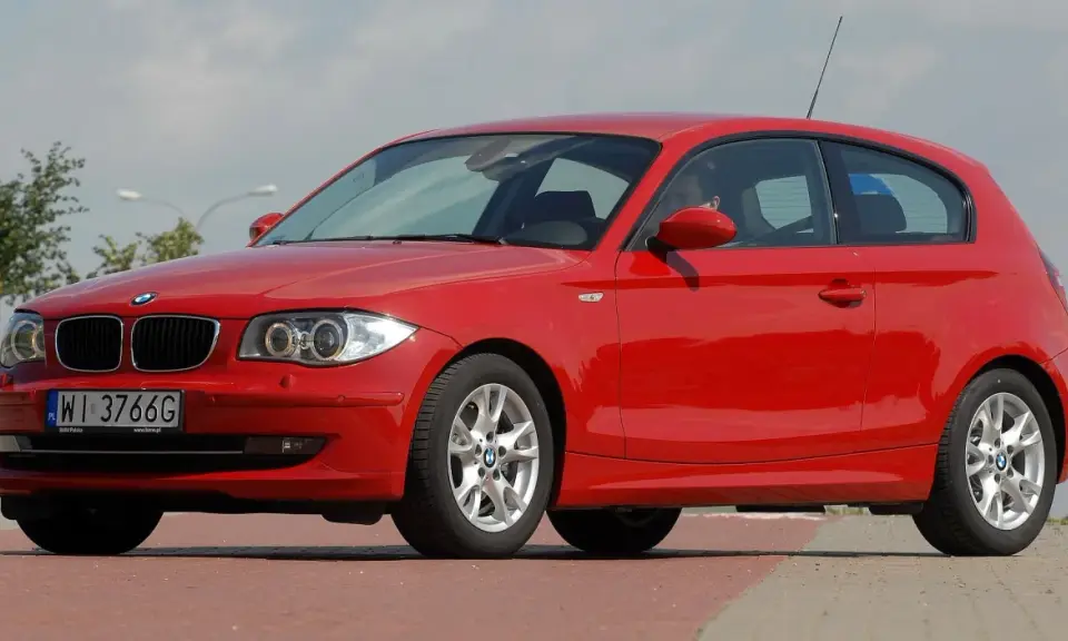 Czerwone BMW serii 1, jeden z klasycznych bmw modele stare, zaparkowane na ulicy.