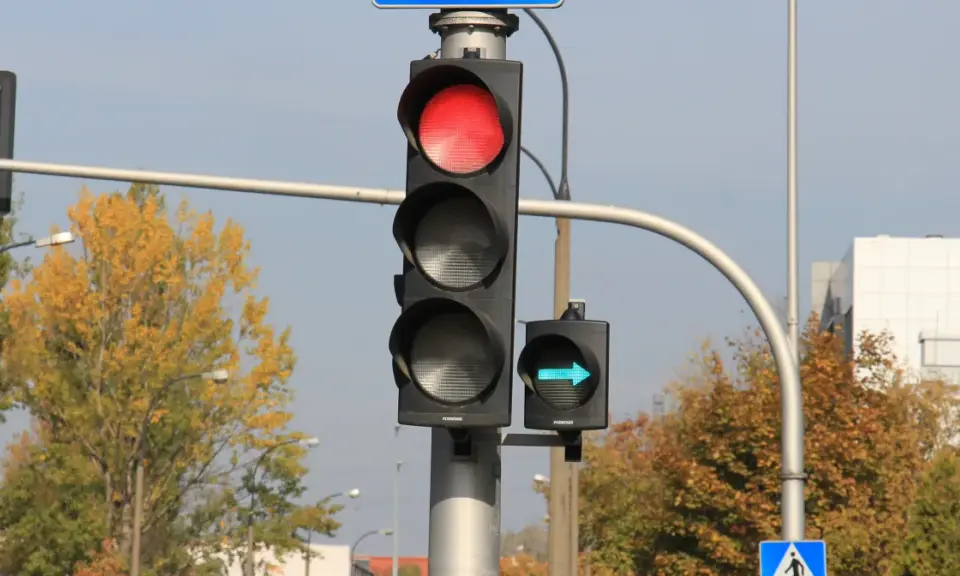 Sygnalizacja świetlna z czerwonym światłem i zielona strzałka wskazująca skręt w prawo.