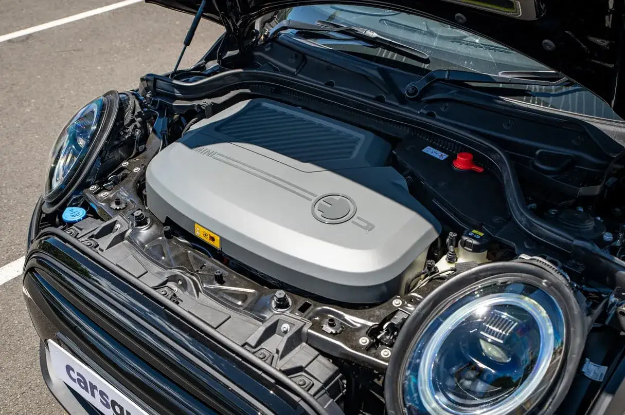 Otwarta maska czarnego Mini Cooper ukazuje nowoczesne mini cooper silniki elektryczne.