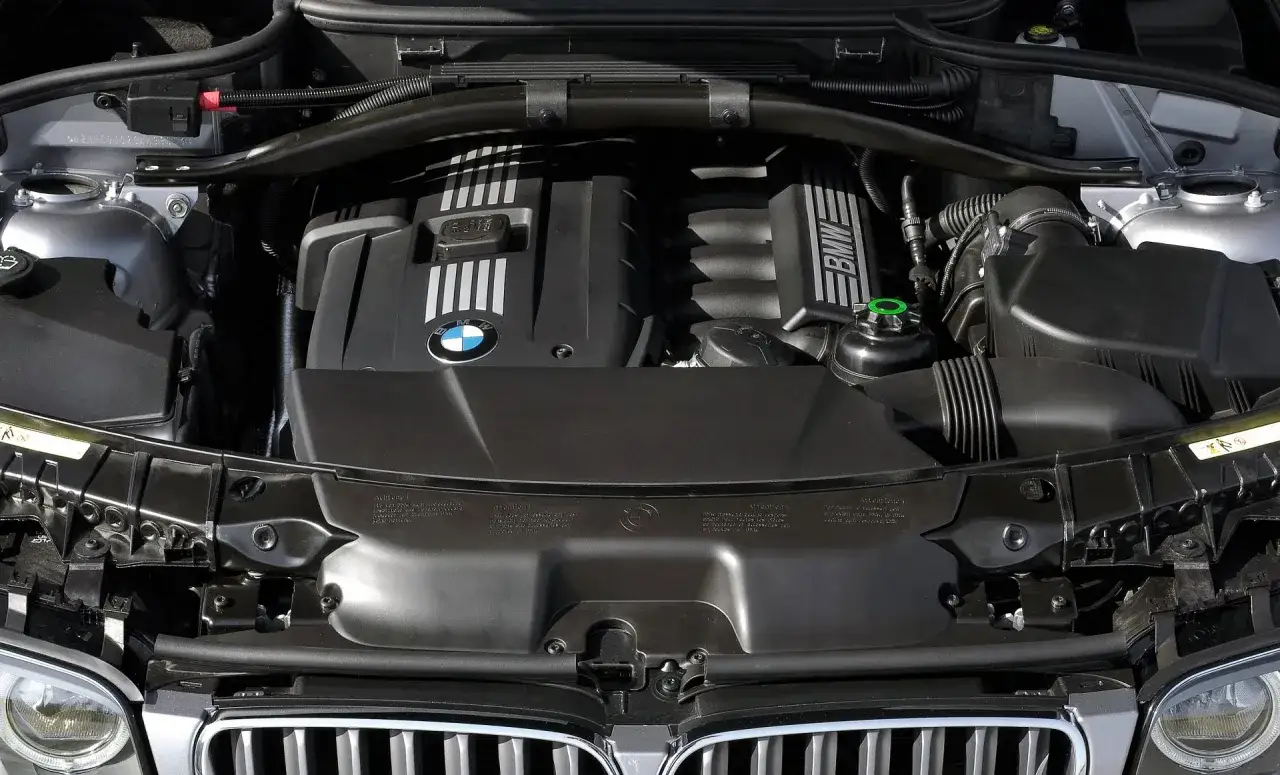 Silnik BMW E83, czarny, z widocznym logo BMW i napisem